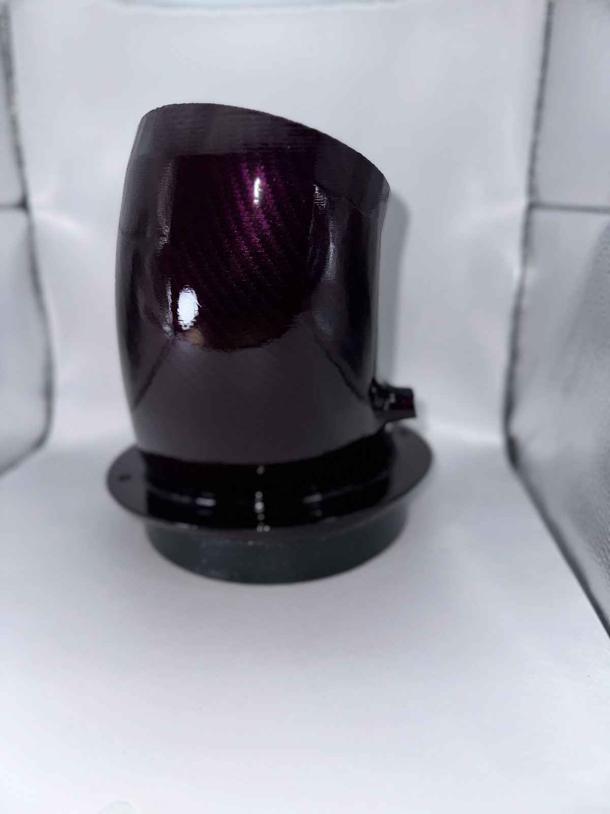 Dark carbon-look intake part on a white backdrop