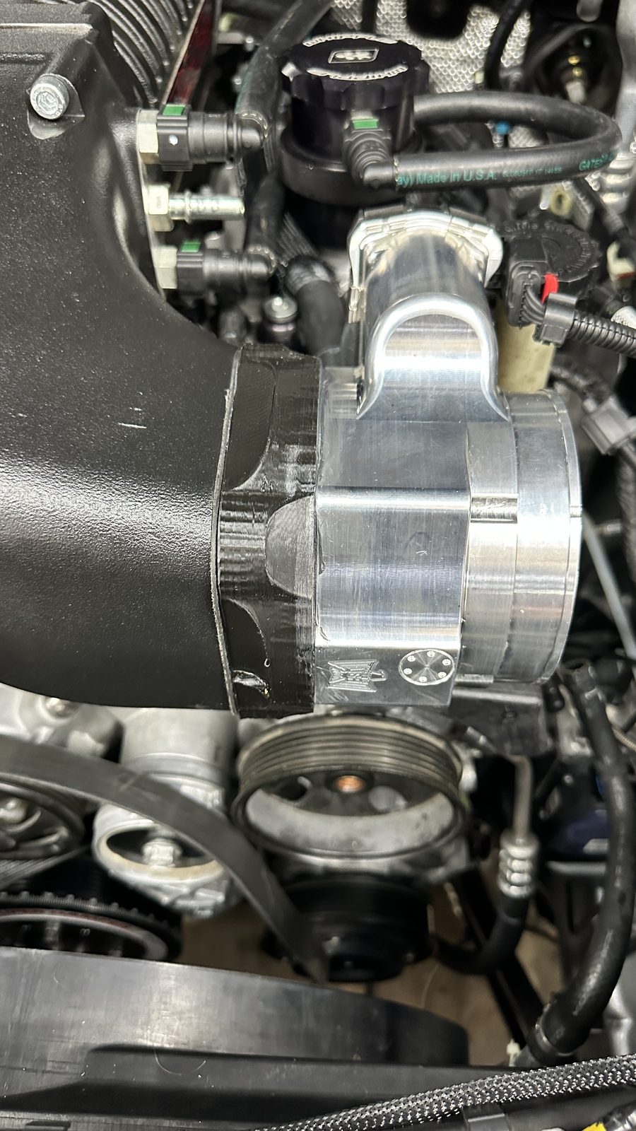Close-up of intake hardware and throttle body adapter components