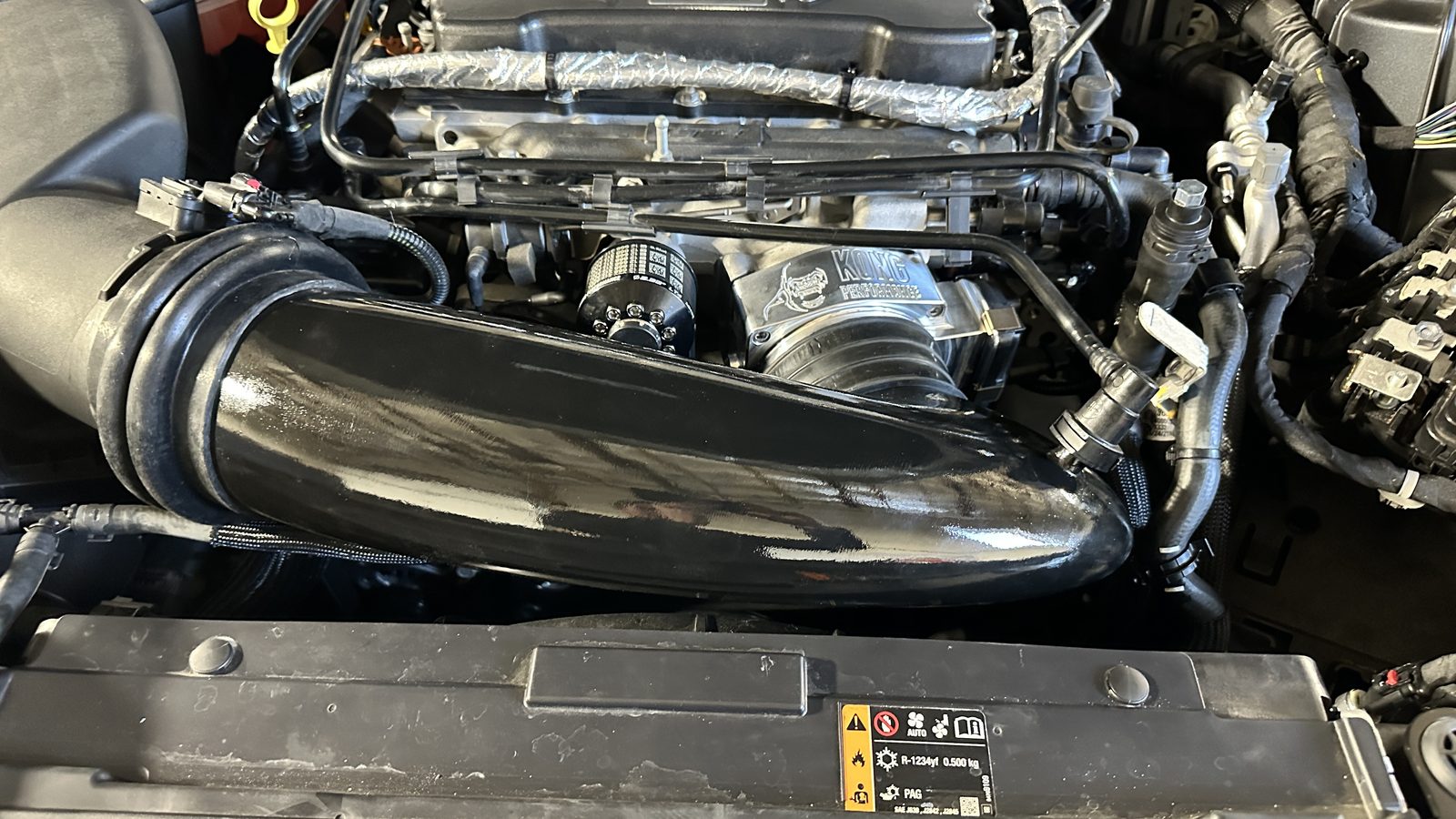 Gloss black intake tube routed across a Cadillac CT5-V Blackwing engine bay